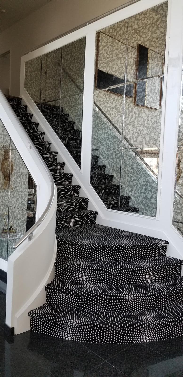 antique mirror wall, curved staircase