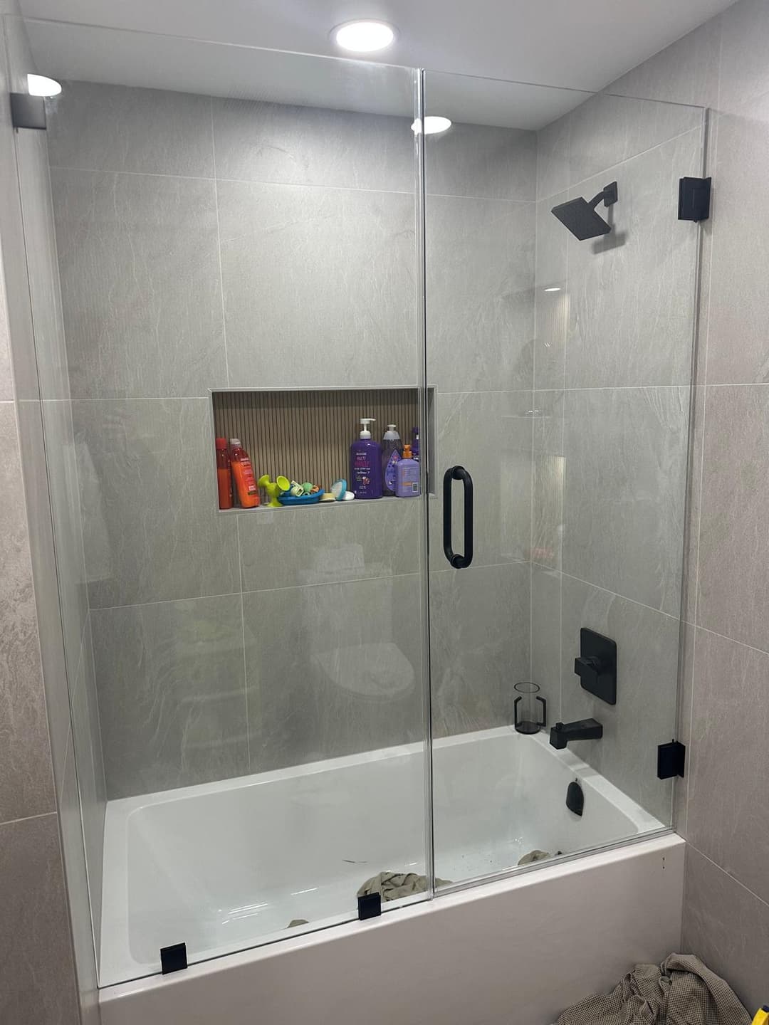 worker installing tub glass panel