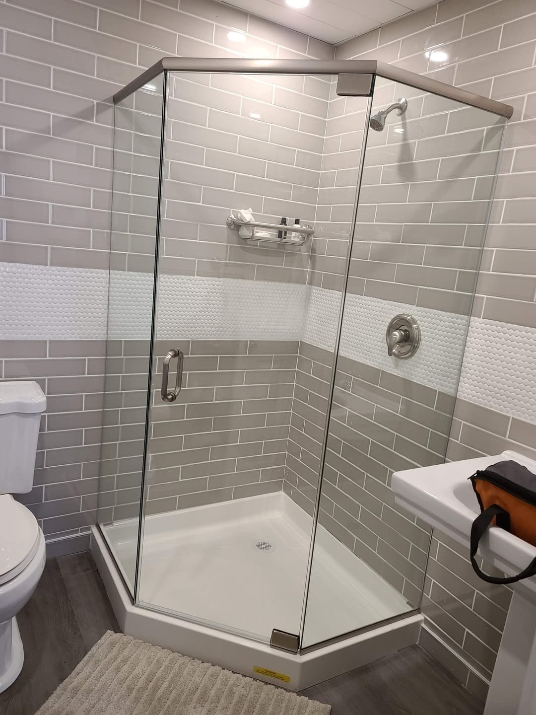 travertine shower, gold hardware, pebble floor