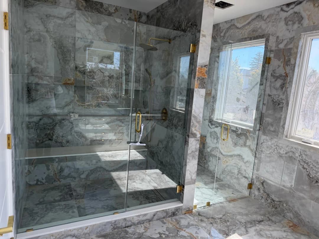 dual-entry marble shower, gold fixtures, wide shot