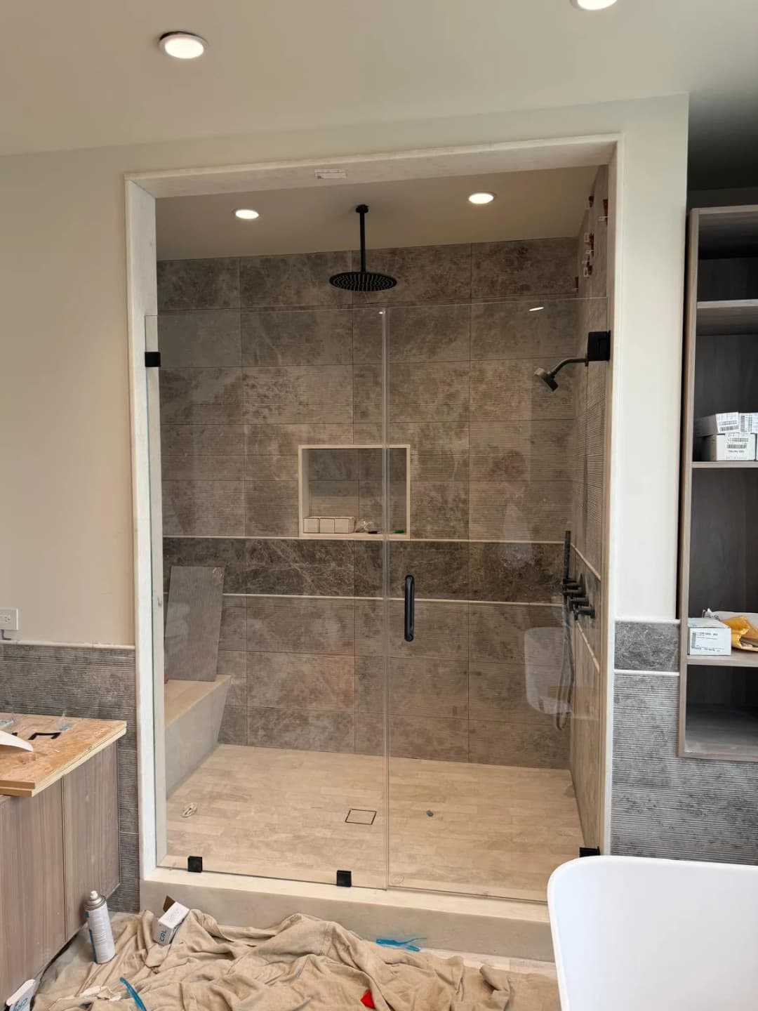 walk-in shower, black hardware, stone tile