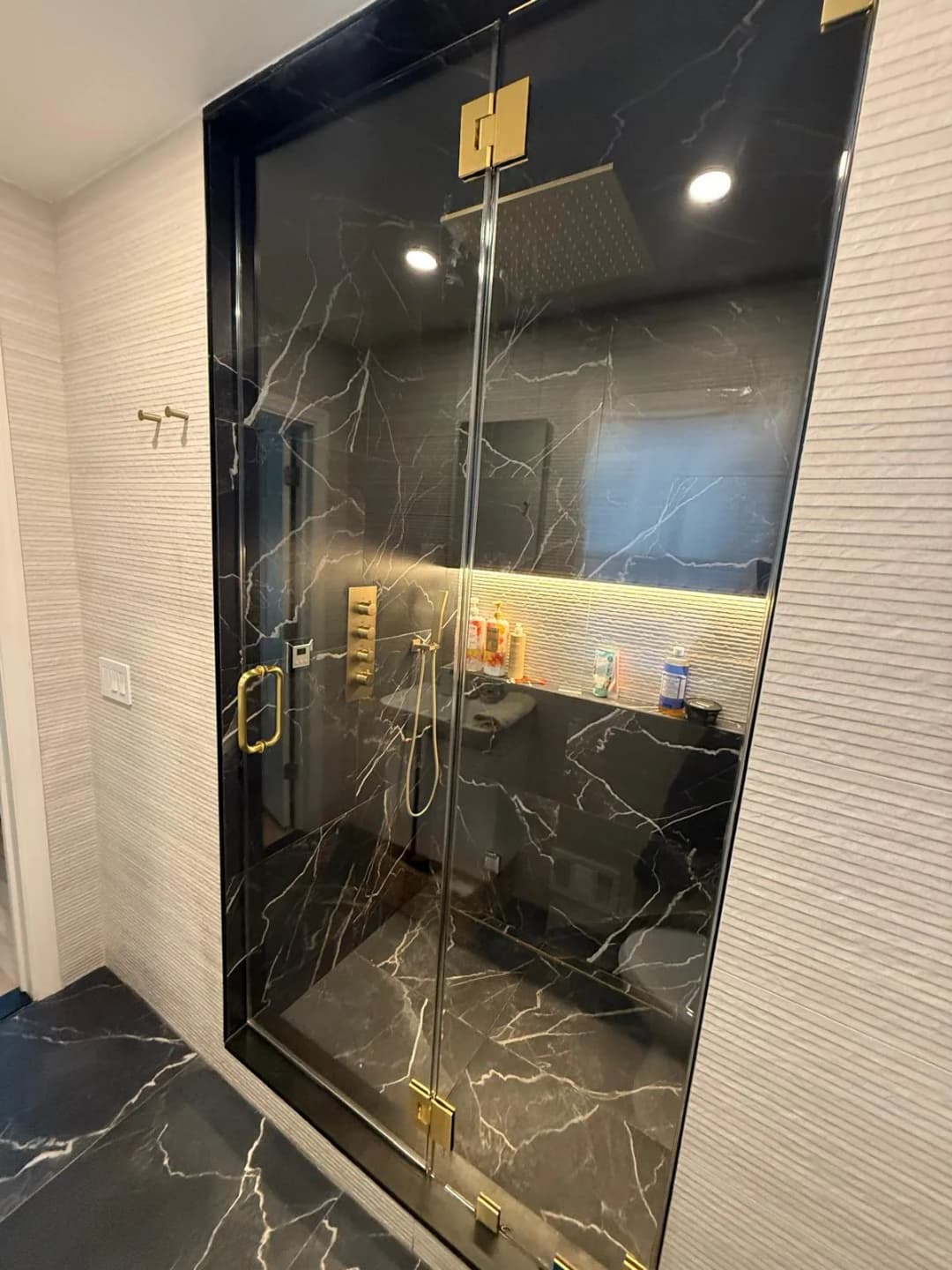 dramatic black marble shower, gold fixtures